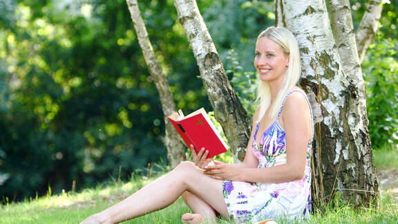 Frau liest Buch im Garten der Sinne 